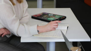 En del av studerandena vid statsvetenskapliga fakulteten känner att studierna orsakar för mycket stress. Studerande skriver anteckningar i ett häfte.