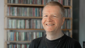 Mainstream-musik intresserar inte Henrik Gustafsson. Henrik Gustafsson poserar leende framför sin cd-hylla.