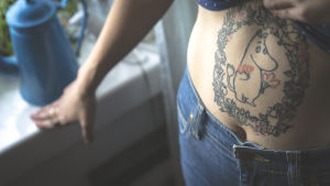 Tatuering föreställande Mumintrollet omringad av en blomkrans på Cecilia Ebbes mage.