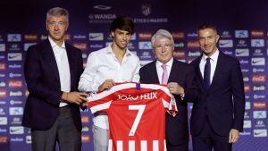 Joao Felix håller upp sin tröja tillsammans med representanter för Atletico Madrid.