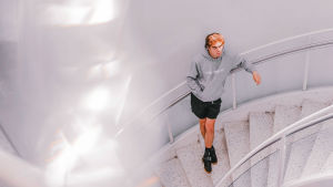 Lauri Haavin mielestä suuri osa Suomessa tehdystä r'n'b:stä on turhan juustoista. Harmaaseen huppariin ja mustiin shortseihin pukeutunut mies seisoo kierreportaikossa ja katsoo oikealle. Portaat ja seinä ovat valkoiset, miehellä on käsi hupparin vatsataskussa. Kuva on otettu yläviistosta.