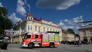 En brandbil fanns också på plats. En brandbil står parkerad framför ett gult stadshus.