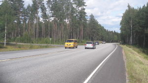 På hemvägen måste jag korsa riksvägen för att ta mig till Ekenäsvägen mot Karis. Bilar kör på en asfalterad väg. Till vänster syns ett avtag till en mindre väg.