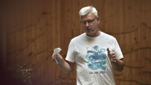 Göran Östberg liknar Vasaregionen vid ett tåg. en man med glasögon pratar till en publik