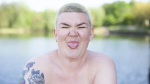 Enni säger att burlesken hjälpt henne snabbare än vad vanlig samtalsterapi hade gjort. Enni Grundström visar tungan och ser glad ut.