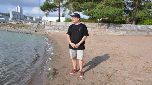 Kim Lindström på stranden vid Pargas centrum. Kim Lindström står på en strand och ser ut mot havet.