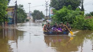 Människor tar sig igenom vattenmassorna i Kerala, Indien 8.8. Räddningsoperation i Kerala efter monsunregn.