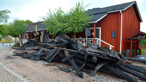 Så här mycket träbalkar har behövt rivas ner från kafébyggnadens innertak. Svartbrända träbalkar utanför restaurangen.