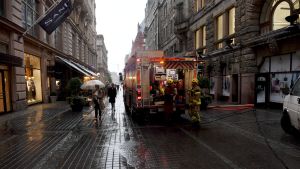 Räddningspersonalen pumpar ut vatten ur en affärslokal på Mikaelsgatan. Brandbil står på Mikaelsgatan i Helsingfors. Räddningspersonalen pumpar ut vatten ur en affärslokal.