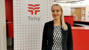 Janni Järvinen, jurist vid Tehy säger att det är slut på gratisarbetet. En kvinna står bredvid en Tehy skylt framför ett rött bord