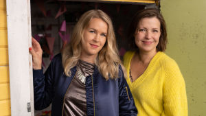 Relationspoddens programledare Hannah Norrena och Eva Frantz. Eva Frantz och Hannah Norrena står i en dörrpost.
