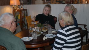 Ellen Järvinen med gäster Ellen Järvinen äter vid ett bord med gäster i Café Källarvinden