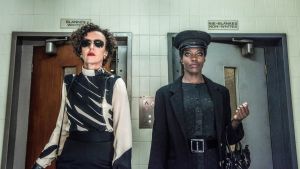 Deutschland 86. Kaksi naista tuimilla ilmeillä alaviistosta kuvattuna, takana kaakeliseinä ja vessan ovet.