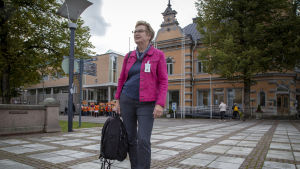 Johanna Ylikoski leder barnskyddet i Raumo som har nått goda resultat med ett nytt arbetssätt Rauman lastensuojelun päällikkö Johanna Ylikoski seisoo aukiolla ja Rauman kaupungintalo näkyy takana.