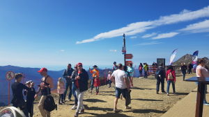 Också en höstvardag är det många besökare på bergstopparna Turister i bergen nära Sotji står vid en utkiksplats. Vissa tar bilder och andra går omkring.