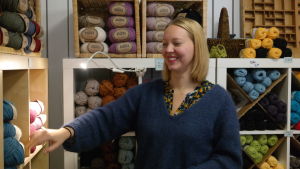 Tone Leganger gick en kurs i hur man öppnar en webbshop. Kursen var till stor nytta. Tone Leganger står vid en garnhylla