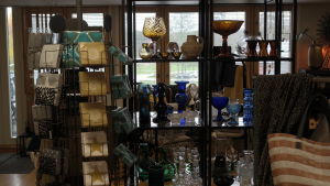 Nagubor och sommargäster besöker butiken också vintertid. Charlotte Vuorio anser att Nagubor vill stöda de lokala affärerna. En hylla med olika konstglas i en inredningsaffär