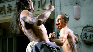 Kaksi gangsteria tappelee ilman paitaa kauhuelokuvassa Suuri yakuzasota (Yakuza Apocalypse)