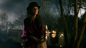 Rose the Hat (Rebecca Ferguson) är karismatisk och Fergsuon är fängslande i rollen. Rose the Hat (Rebecca Ferguson) sitter på marken med en behhållare av människogas i handen.