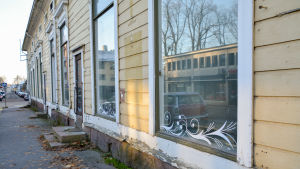 Hela fastigheten är till salu. Det är tomt bakom varje fönster. tom affärslokal i gult trähus