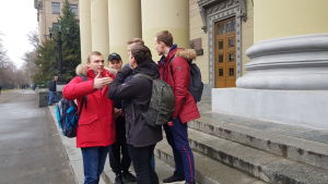 Studerande vid järnvägsuniversitetet diskuterar politik. En grupp studerande står och diskuterar på trappan till en byggnad.