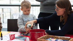 Pysselhörnan kryllade av barn hela dagen. Det var populärt att bygga en egen BUU-reflex. BUU-dagen i Hfors 2019. Mamma hjälper sin son att stämpla ett papper med BUU-stämpeln.