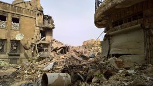 Sodan raunioittama Aleppo maaliskuussa 2017, talojen raunioita ja hiekkasäkkejä ikkuna-aukoissa.