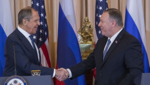 I december ifjol var det idel leenden då USA:s utrikesminister Mike Pompeo träffade sin ryska kollega Sergej Lavrov. Ett år senare anklagade Pompeo Ryssland för en stor cyberattack på USA. Två män i kostym skakar hand med flaggor i bakgrunden.
