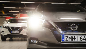 Sähköauto etualalla ja polttomoottoriauto takana.