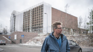 "Det nya tornet i Sandkulla blir medelstort jämfört med våra andra torn", säger projektchef Arto Mettinen från Helsingforsregionens miljötjänster. I bakgrunden syns vattentornen i Ilmala. De är regionens största vattentorn. En man står utomhus. Vädret ser kallt ut. Han skådar ut mot sin vänstra sida.