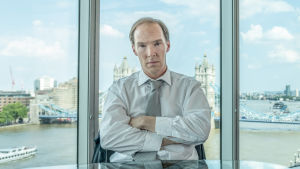 Brexit - temppu ja miten se tehtiin. Mies kädet puuskassa jonkinlaisessa toimistohuoneessa, jossa taustalla isot ikkunat ja vesimaisema.