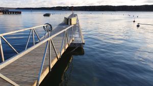 Bryggan byggdes på samma ställe som förr. Lång betongpontobrygga sedd från stranden.