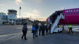 Passagerare stiger på ett av WizzAirs rosa-lilafärgade flygplan på Åbo flygplats.