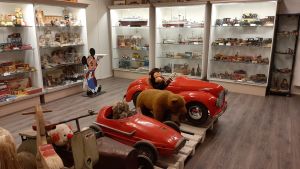 Leksaker i Casagrandes leksaksmuseum. Musse Pigg, röda trampbilar och andra leksaker på ett leksaksmuseum.