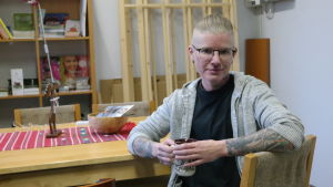 Alexander Rancken upplevde målbrottet i trettioårsåldern. Alexander Rancken sitter vid ett bord med en tekopp i handen
