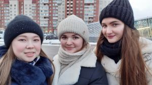 Alina, Anja och Kristina är patrioter som älskar sitt hemland. Tre unga vinterklädda kvinnor ler blygt mot kameran.