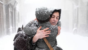 Nainen halaa lasta lumisateessa silmät kiinni