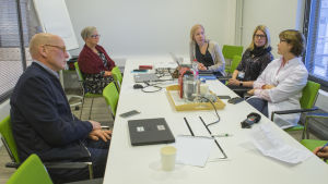 Varje vecka ordnar polikliniken ett gemensamt möte med sakkunniga läkare för att diskutera de mest utmanande patienternas tillstånd och vård. Fem personer sitter kring ett mötesbord och diskuterar.