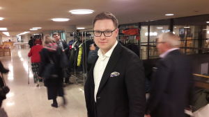 Samlingspartiets gruppordförande Daniel Sazonov skulle inte kalla budgeten för nedskärande. Daniel Sazonov från samlingspartiet utanför fullmäktigesalen i Helsingfors.