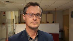 Martin Andersson granskar Nickby sjukhus historia ur ett kritiskt perspektiv. Porträtt av en medelålders man med mörkblå blazer.