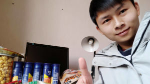 Hu Chuanjun, anställd på ett kinesiskt företag har precis fått en matleverans skickad till sig. 35 anställda på företaget sitter i karantän eftersom de varit med och byggt upp ett provisoriskt sjukhus för coronaviruspatienter. En kille gör tummen upp när han sitter i karantän efter att han fått en massa mat till sig.