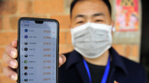 Lokalpolitikern Ying Wenwei visar upp hur många steg han har gått varje dag. Wechat räknar hur många steg användaren går varje dag och rankar användarna och jämför dem med varandra. En man håller upp en mobiltelefon och visar hur många steg han har gått varje dag.