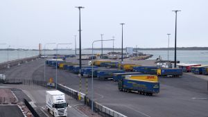 Västra hamnen i Hangö hör till de största i Finland. Långtradare i en hamn, i bakgrunden ett fartyg.