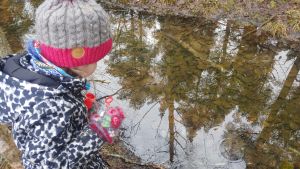 Elvi speglar sig i vatten hemma på gården. Elvi Sihvonen peilaa pihapiirin lammesta maisemaa.