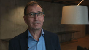 Biträdande riksåklagare Jukka Rappe. Medelålders man med glasögon och ljusblå kragskjorta.