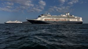 Systerfartygen Zaandam och Rotterdam är på väg mot Fort Lauderdale i Florida där passagerarna evakueras. Zaandams systerfartyg Rotterdam (i förgrunden) har kommit till undsättning för att leverera förnödenheter och evakuera friska passagerare. De båda fartygen fotograferade i Panamaviken på lördagen.
