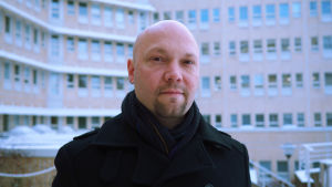 Thomas Sundell reder ut begreppen kring distansundervisning och hemundervisning. Jurist på Regionförvaltningsverket i Vasa står framför stort ämbetshus i flera våningar. Det är snö på marken.