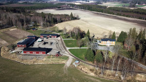 Strikta regler för hygien och hur man umgås infördes på Malmgård i Sjundeå då det blev klart vad coronaviruset leder till. En vy från luften över Malmgård i Sjundeå, med gult karaktärshus och röda arbetsbyggnader.