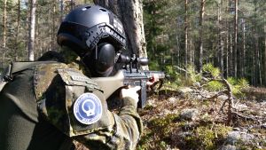 I airsoft används vapen som ser väldigt äkta ut. En airsoftspelare siktar med sitt vapen.