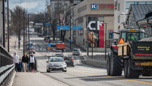 Mannerheimgatan går genom Borgå centrum. De flesta husen längs med gatan är relativt låga. Arkivbild. Traktor och bilar kör längs gata i staden